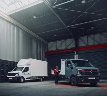 A professional inspects a Renault Trucks Master Red EDITION OFFROAD chassis cab JPM tipper and tool box, with a dry box van version positioned in the background. This picture highlights Renault Trucks' flexibility to offer different factory-fitted body options direct to the customer.